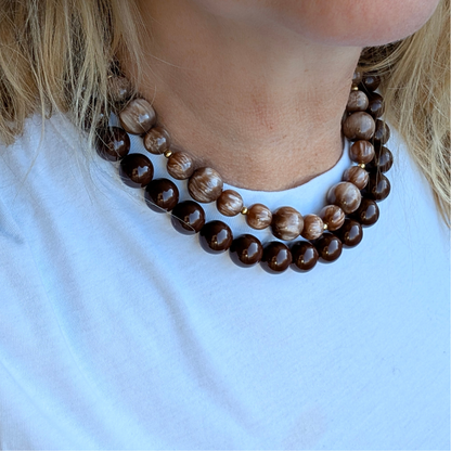 model met T-shirt en 2 bruinen kettingen