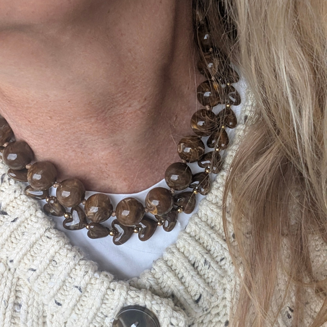 model met bruine grote kralenketting en hartjes kralenketting