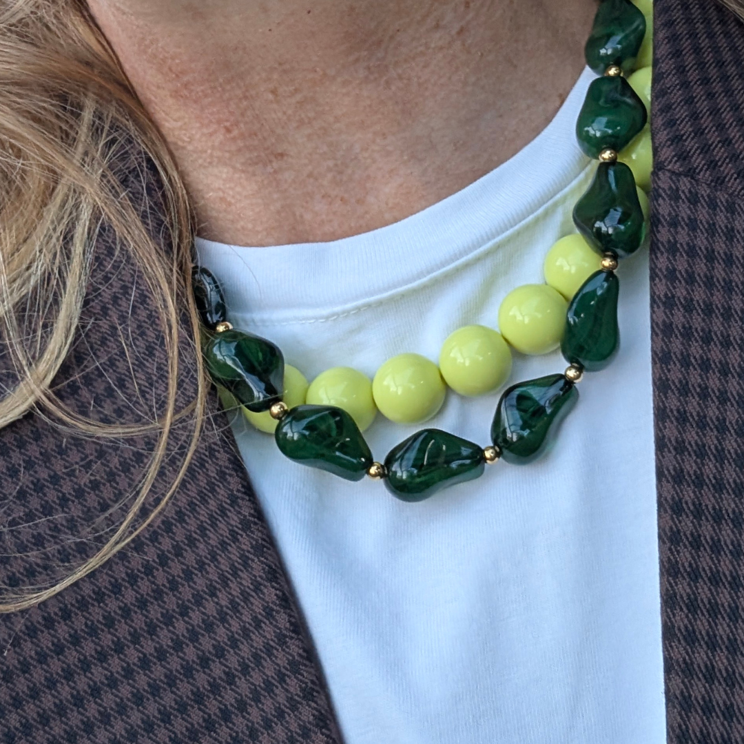 model met limegroene en chunky donker groen grote kralenketting