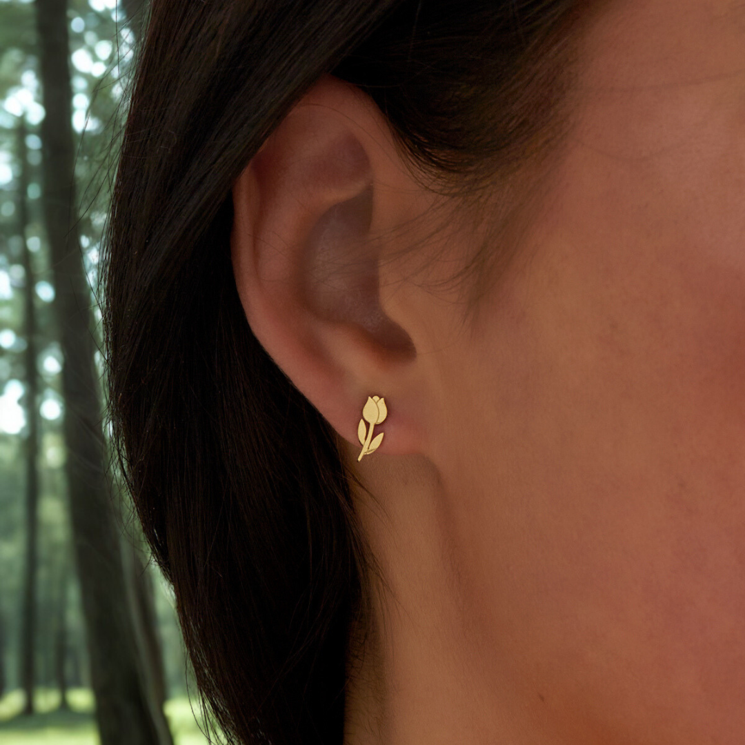 model met zilveren tulp oorknopjes achtergrond een bos