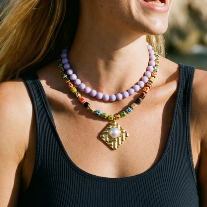 Gekleurde keramische kralenketting gedragen met lils paarse kralenketting door model.