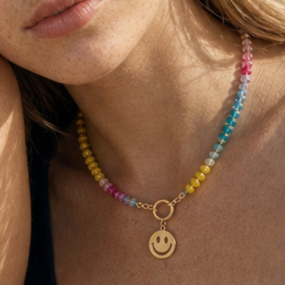 Model draagt een multicolor kralenketting met goudkleurige smiley bedel van Casa Jadel