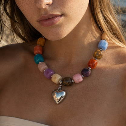 Model draagt een multicolor kralenketting met grote zilverkleurige hart bedel van Casa Jadel