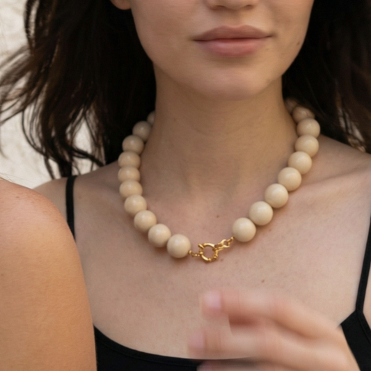 Naturel grote kralenketting met boeislot gedragen door model. 