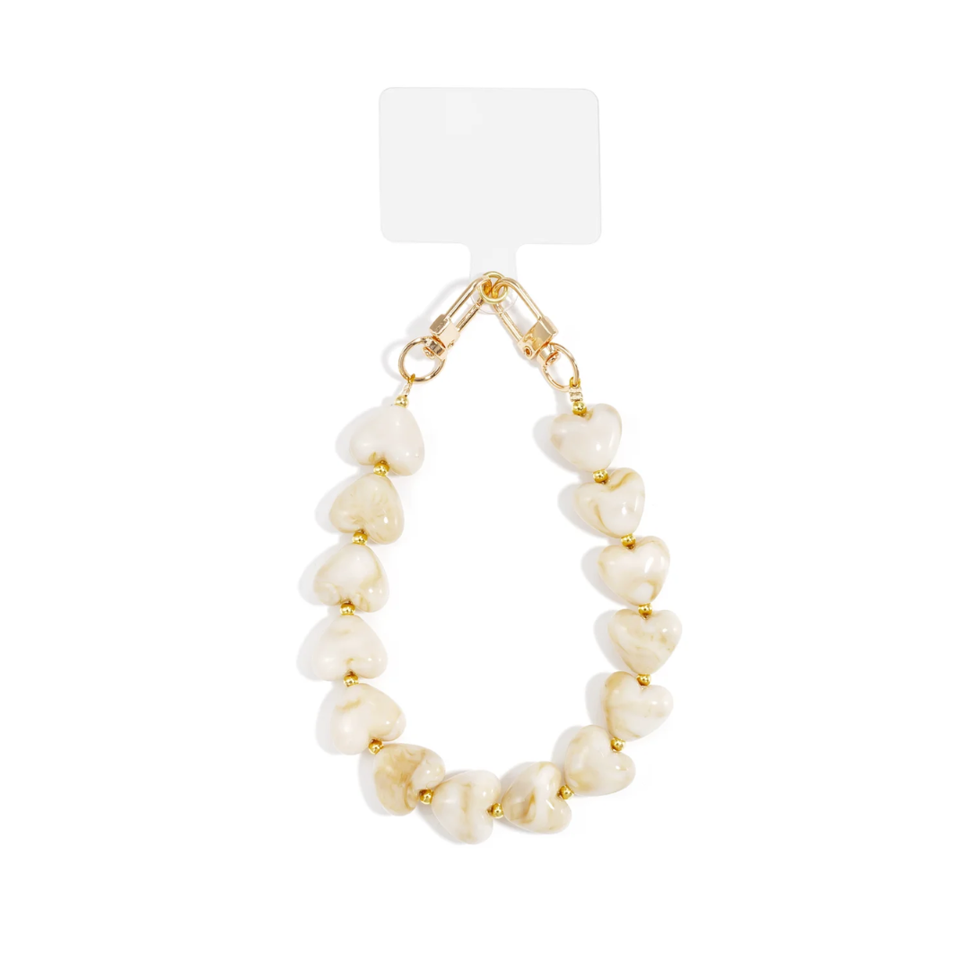 Offwhite marble telefoonkoord met XL hartjeskralen en goudkleurige details op witte achtergrond