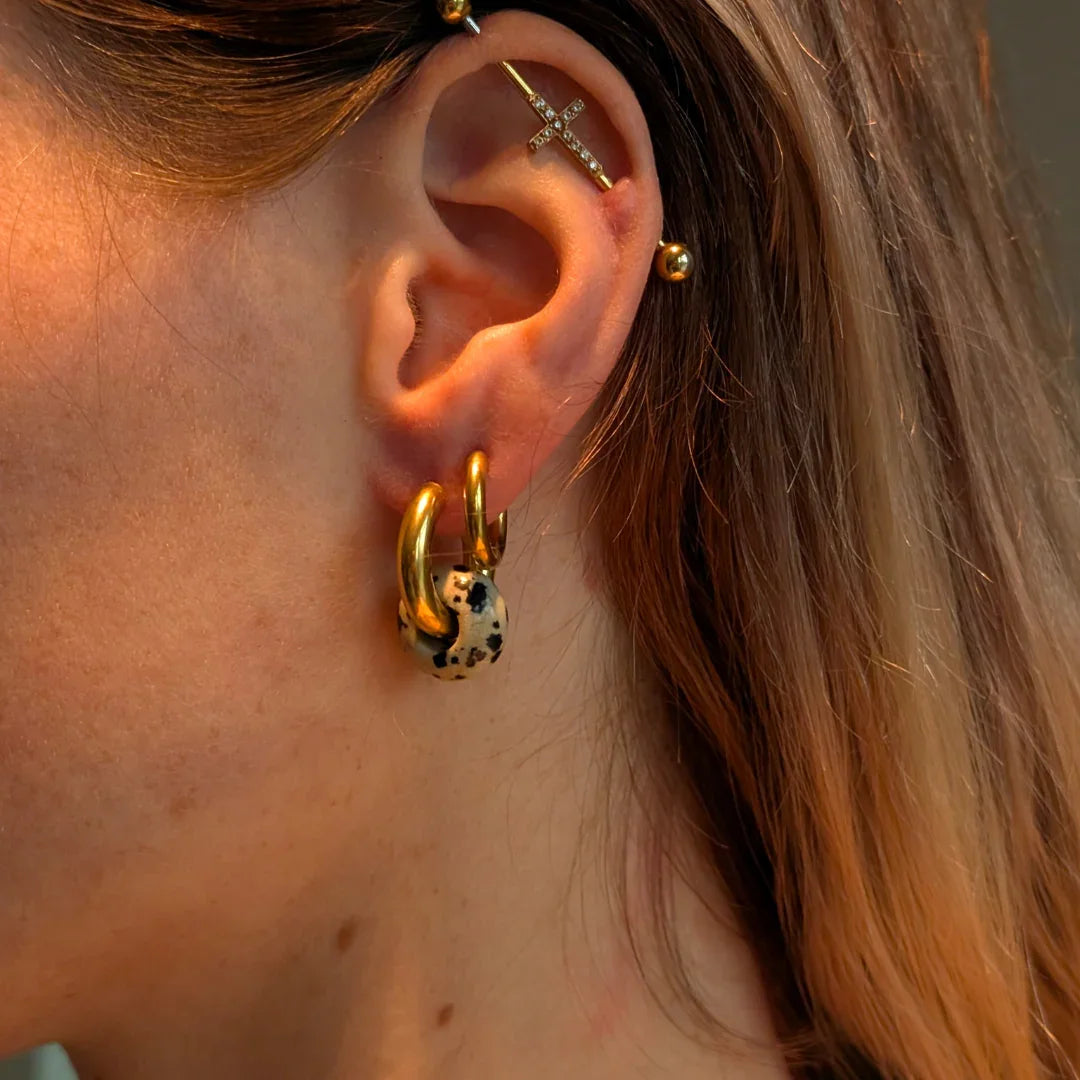 oor met Gouden oorringen met dalmatiër jaspis-look donutbedels van Casa Jadel.