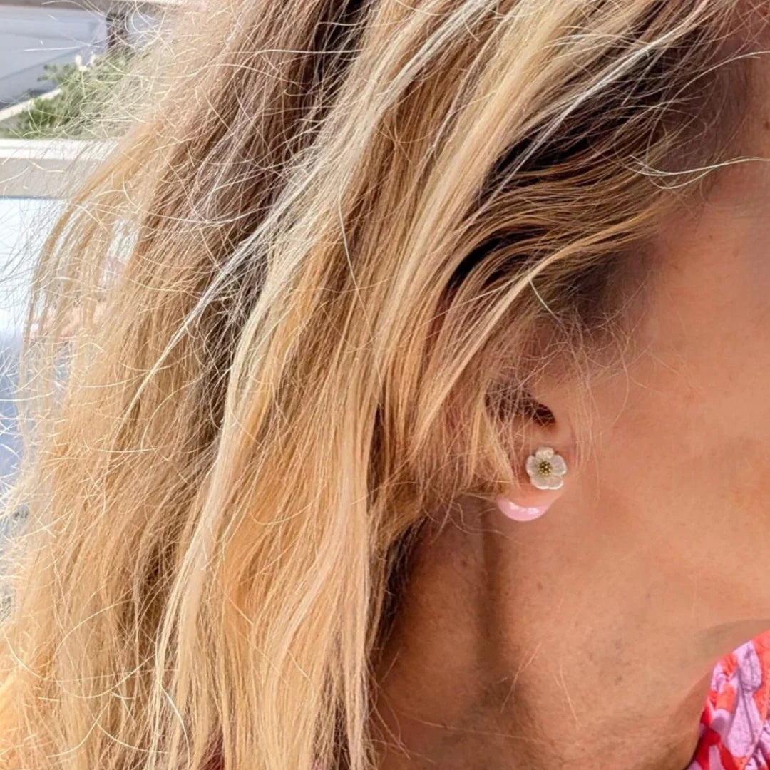 oor met parelmoer bloemetje met daarchter een roze bal