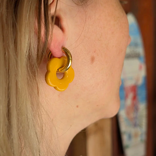 Gouden oorringetje met mosterd geel bloem