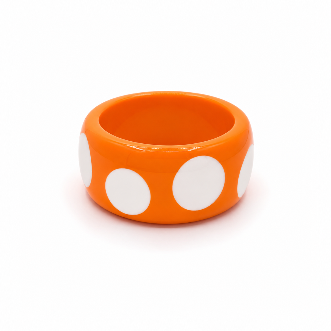 Oranje resin bangle armband met grote witte stippen van Casa Jadel.