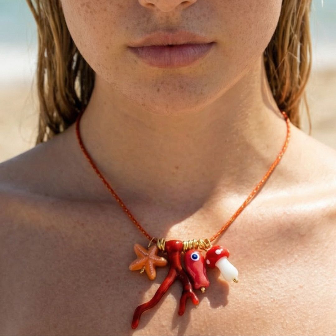 Oranje kralenketting met bedels van zeester, rood koraal en paddenstoel – Ibiza style dames ketting van Casa Jadel