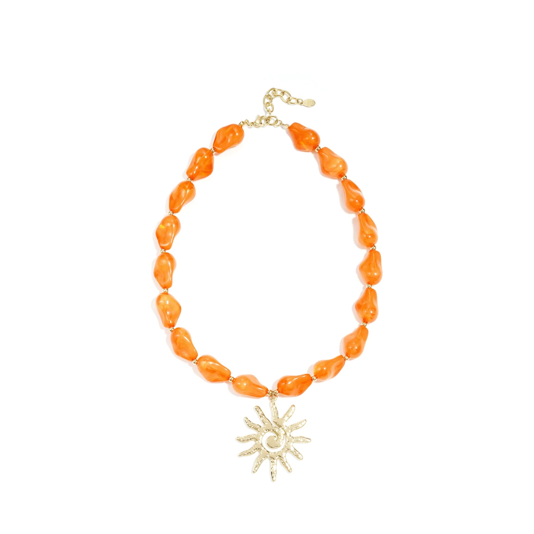 Oranje kralenketting met grote goudkleurige zon bedel en goudkleurige details