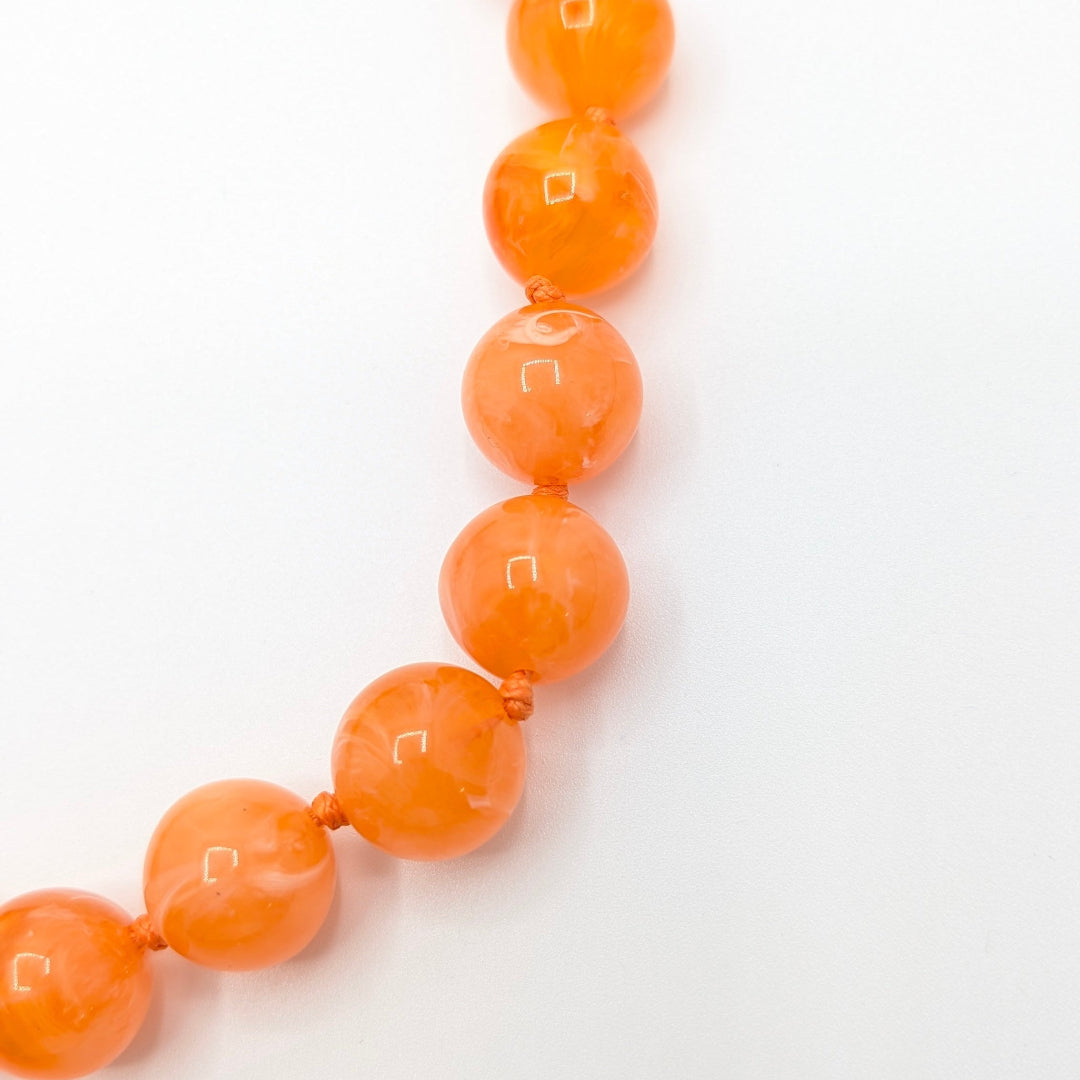 Oranje gemarmerde grote kralenketting met glossy marble kralen detail