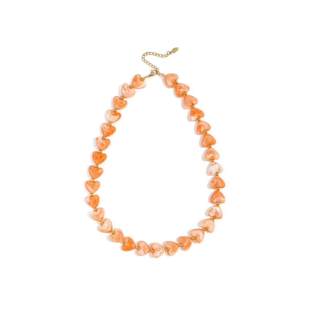 Oranje hartjesketting met gemarmerde hartvormige kralen en goudkleurige details van Casa Jadel