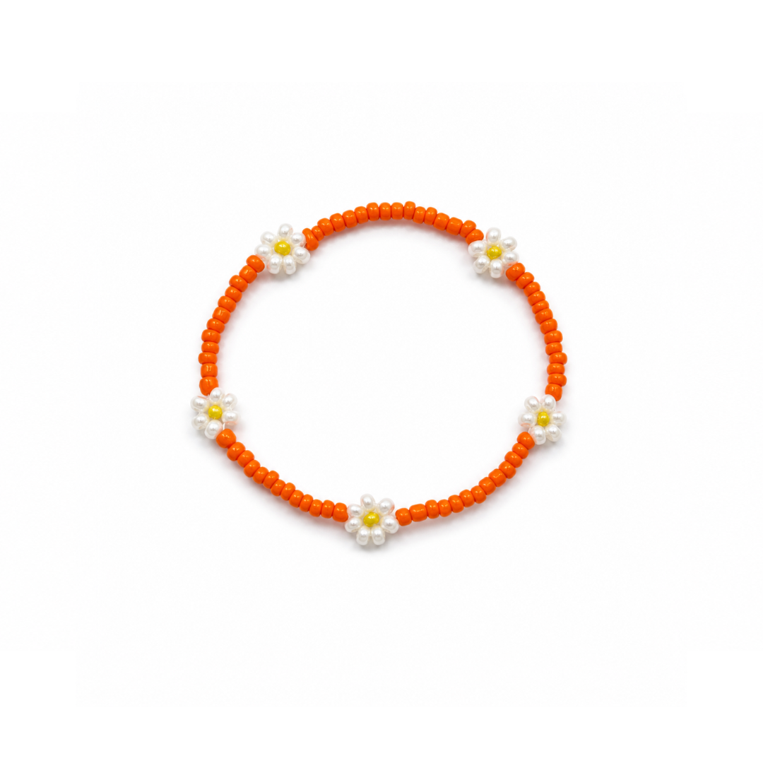 Oranje kleine kralenarmband Saar met witte bloemen en gele hartjes op witte achtergrond