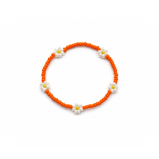 Oranje kleine kralenarmband Saar met witte bloemen en gele hartjes op witte achtergrond