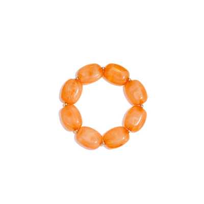 Oranje kralenarmband met marmerlook kralen en gouden accenten op witte achtergrond