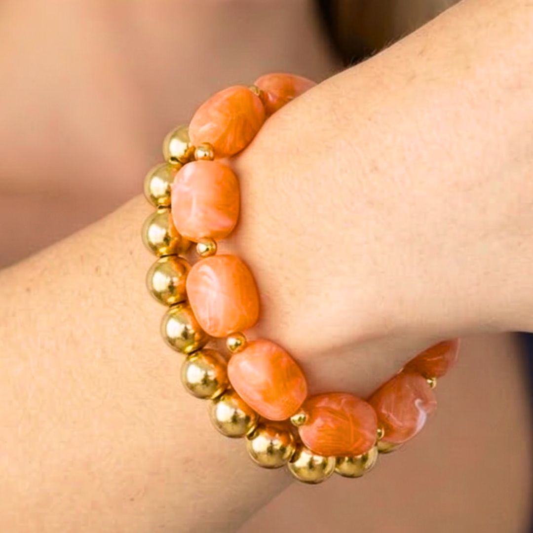 Oranje kralenarmband met goudkleurige kralen gedragen om de pols – zomerse dames armband van Casa Jadel in Ibiza style.