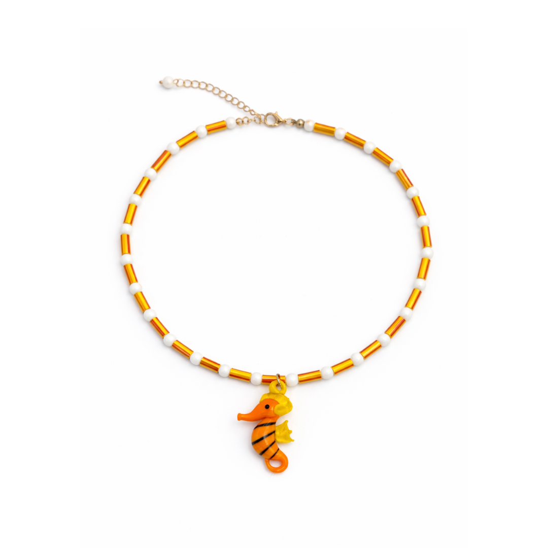 Oranje kralenketting met glazen zeepaardje en witte kralen