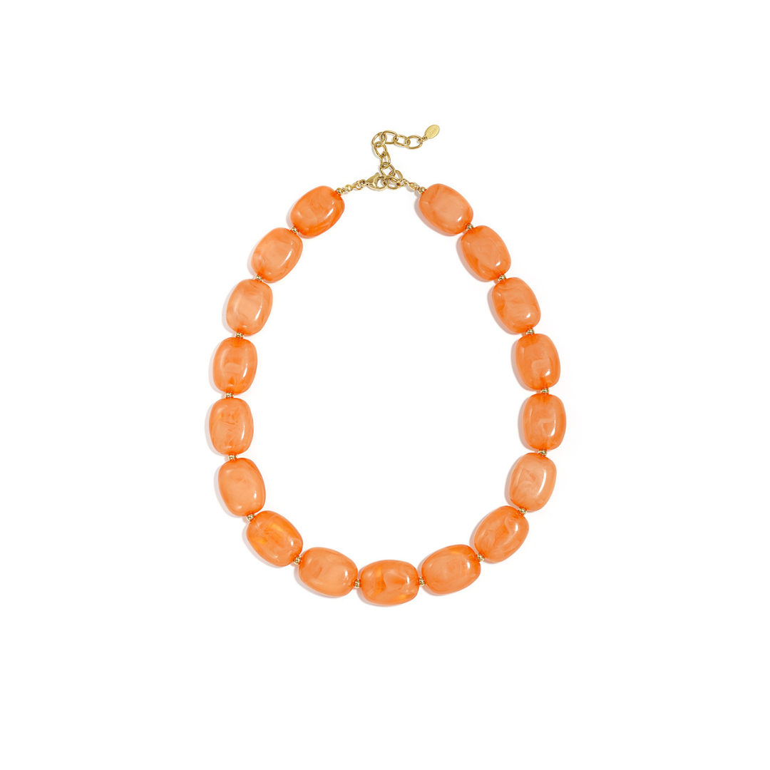Oranje kralenketting met marmerlook kralen en gouden accenten op witte achtergrond