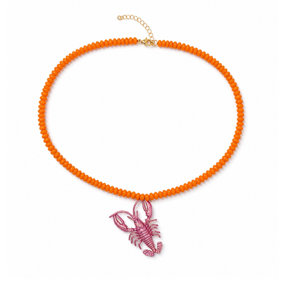 Oranje lange kralenketting met roze metallic kreeftbedel van Casa Jadel