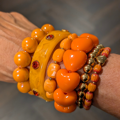 arm met oranje armbanden stack gouden details