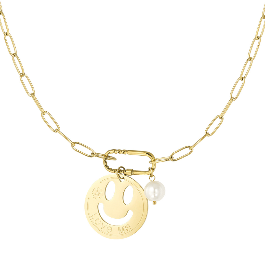 Gouden schakelketting met smiley bedel met tekst Love Me en witte parel hanger, trendy statement ketting voor dames