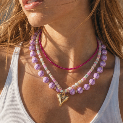 Paarse kralenketting met gouden hartbedel gecombineerd met roze kralenketting voor dames, kleurrijke Ibiza sieraden van Casa Jadel.