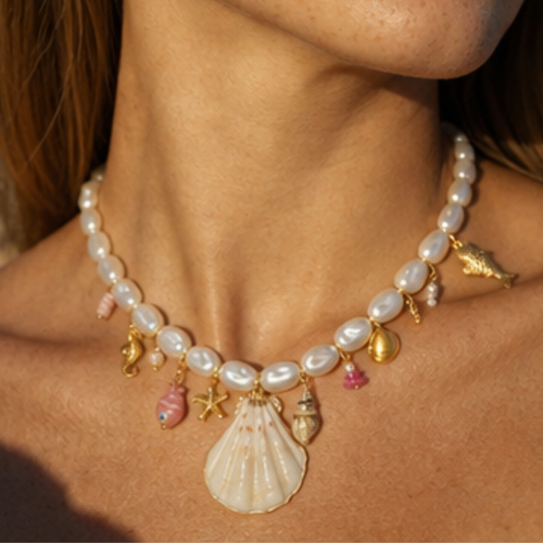 Witte parelketting met schelpen bedels en roze vis