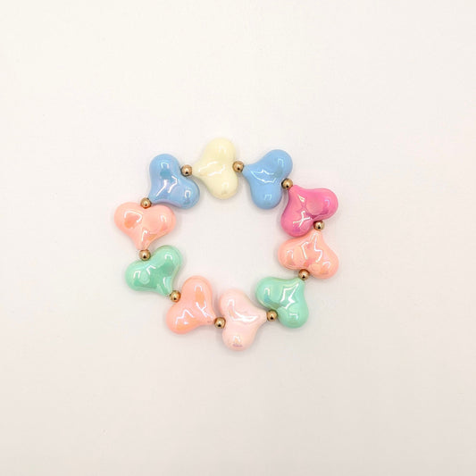 Pastel hartenarmband met glanzende hartkralen in zachte kleuren en goudkleurige tussenkraaltjes.