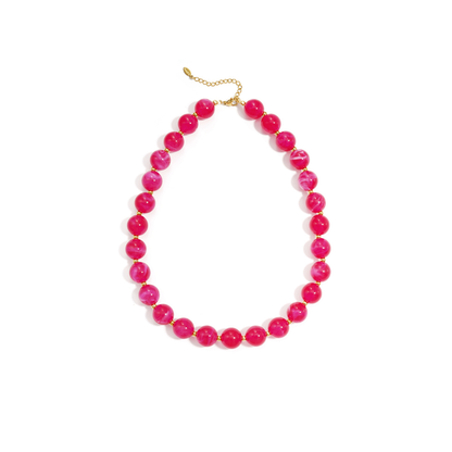Rode gemarmerde kralenketting met goudkleurige accenten op lichte achtergrond.