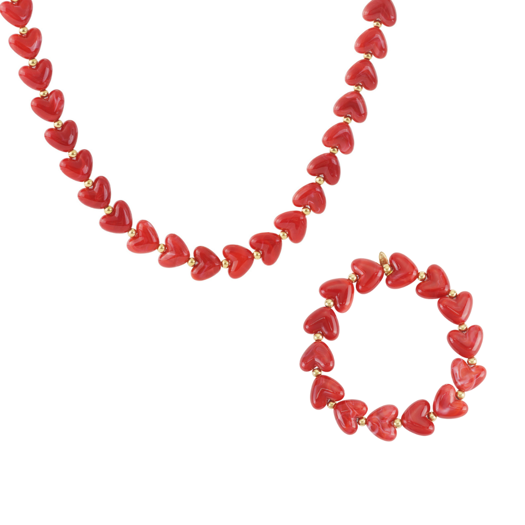 Rode hartjes kralenketting en bijpassende armband met glanzende marmerlook kralen en goudkleurige details op witte achtergrond.