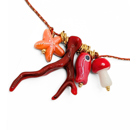 Details van de rope ketting met zeester koraal vis en paddenstoel bedels met goudkleurige details van Casa Jadel