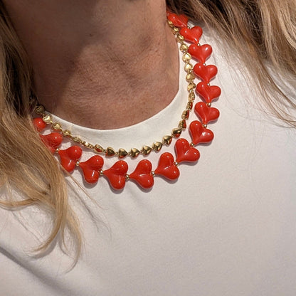 rode hartjes ketting met gouden detail en gouden hartjes ketting op wit tshirt