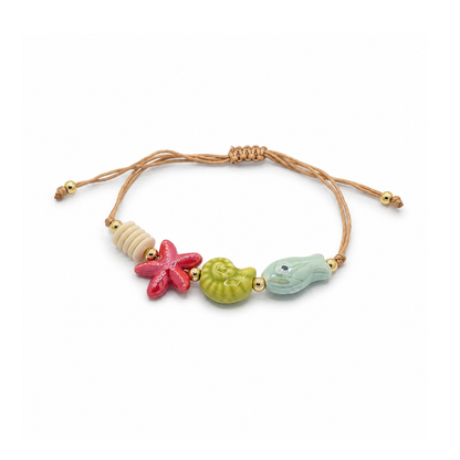 Verstelbaar rope armbandje met rode zeester, groene schelp, lichtblauwe vis en goudkleurige details.