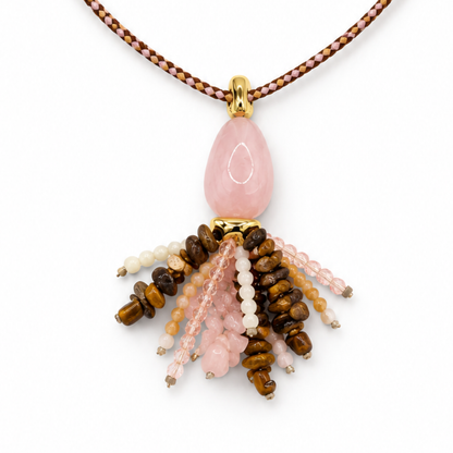 Detail van de glanzende roze druppelhanger met goudkleurige kapjes en een kwastje van bruine, roze, perzikkleurige en crème kraaltjes.