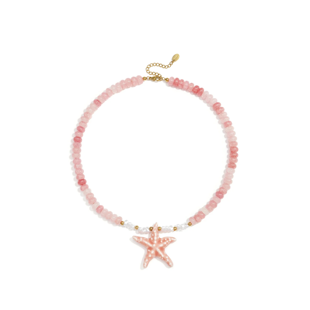 Roze glazen kralenketting met grote roze statement zeester en goudkleurige details van Casa Jadel.