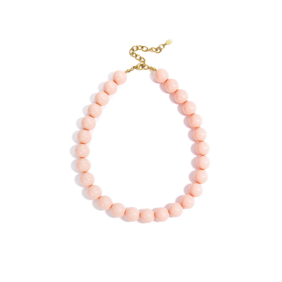 Roze chunky kralenketting met grote ronde glanzende kralen en goudkleurige sluiting op witte achtergrond.