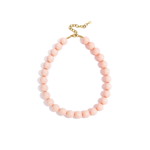 Roze chunky kralenketting met grote ronde glanzende kralen en goudkleurige sluiting op witte achtergrond.