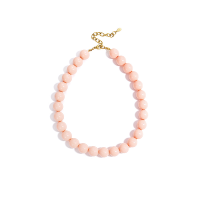 Roze chunky kralenketting met grote ronde glanzende kralen en goudkleurige sluiting op witte achtergrond.
