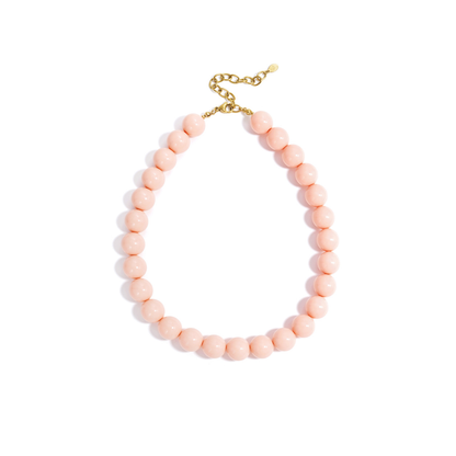 Roze chunky kralenketting met grote ronde glanzende kralen en goudkleurige sluiting op witte achtergrond.