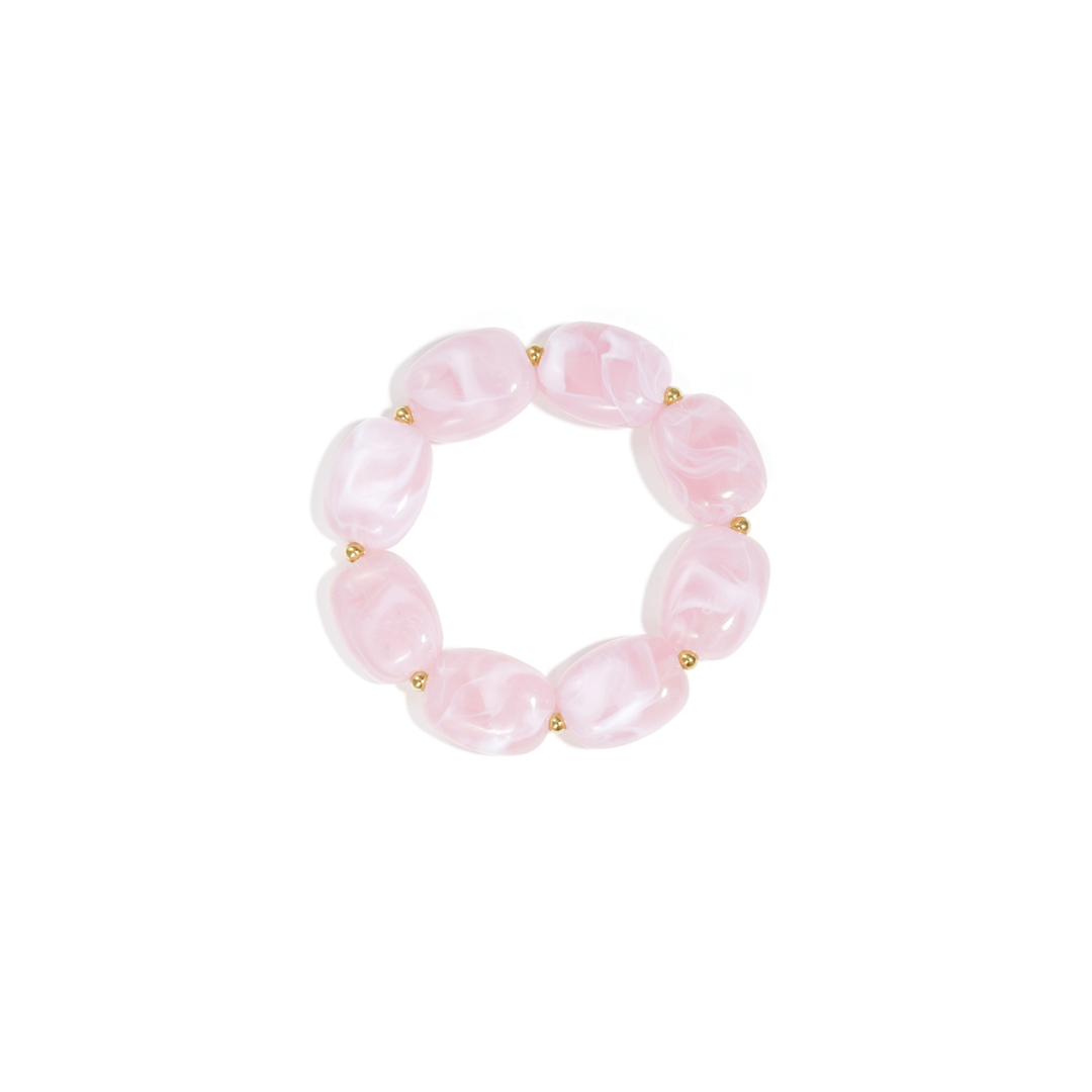 Roze kralenarmband met marmerlook en gouden tussenkralen op witte achtergrond