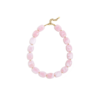 Roze kralenketting met marmerlook en gouden details op witte achtergrond