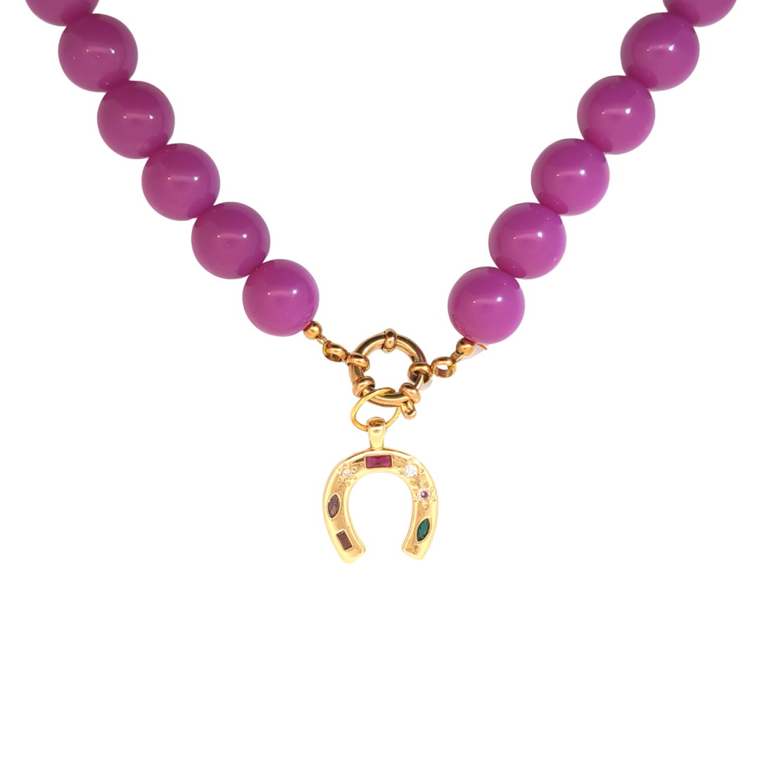 Roze kralenketting met een goudkleurige hoefijzer bedel met gekleurde steentjes, Ibiza-style sieraad van Jadel.