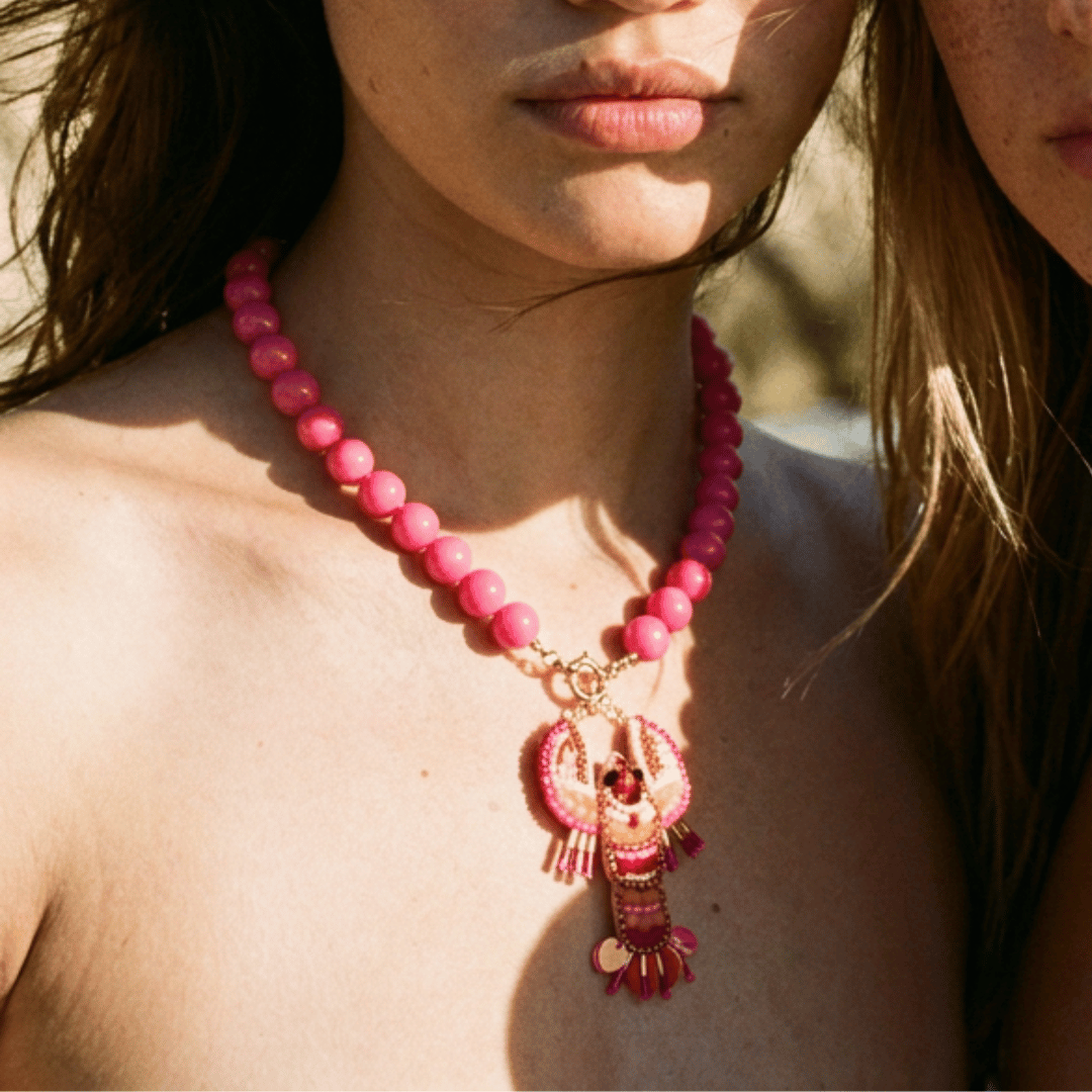  Model draagt roze kralenketting met kreeft hanger van Casa Jadel
