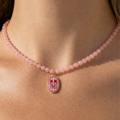 Model draagt roze kralenketting met pink ribbon bedel van Casa Jadel
