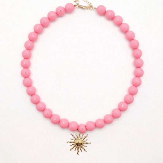 Zuurstok roze kralenketting met goudkleurige zon bedel in Ibiza style van Casa Jadel
