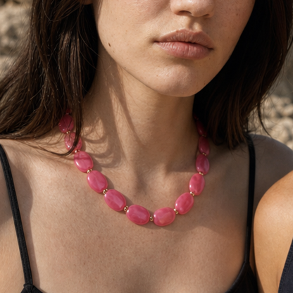 Model draagt een roze ovale kralenketting van Casa Jadel