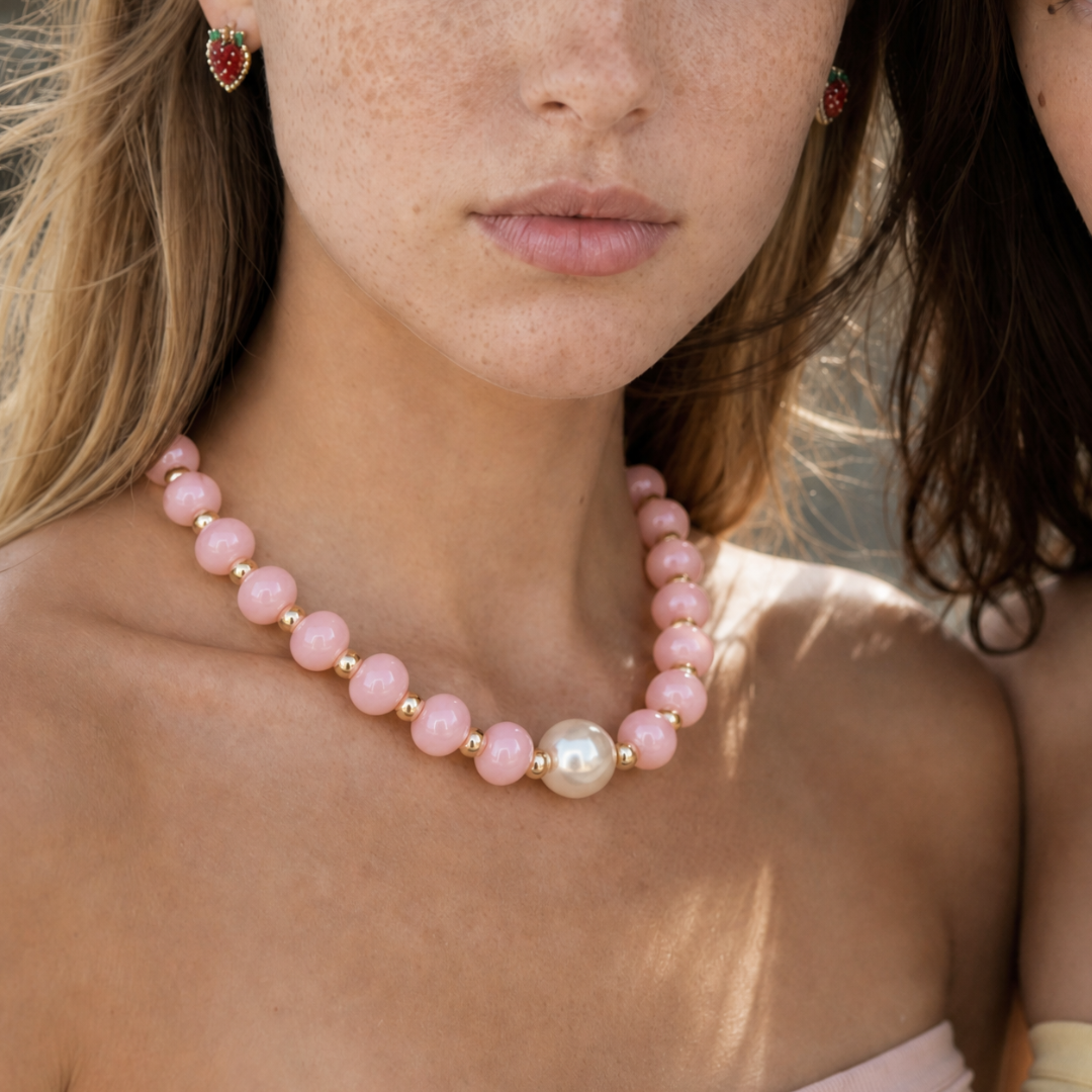 Model draagt een roze ovale kralenketting van Casa Jadel