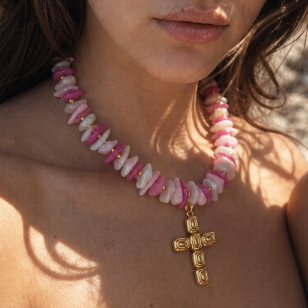 model draagt roze witte schelpen kralenketting met gouden kruis bedel van Casa Jadel
