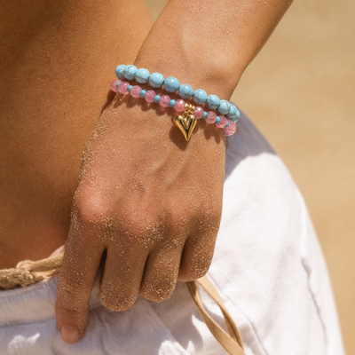 Roze glazen kralenarmband met lang hart bedel